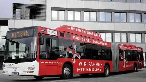 Das Bild zeigt einen Gelenkbus der MIT.BUS GmbH, der mit Erdgas fährt. Darauf stehen Werbesprüche wie "Wir geben Erdgas!" und "Für eine saubere Region."